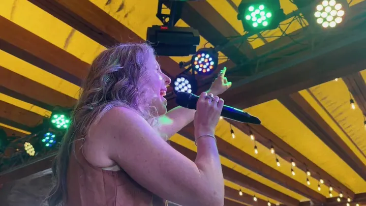 Lead singer belting under green stage lights